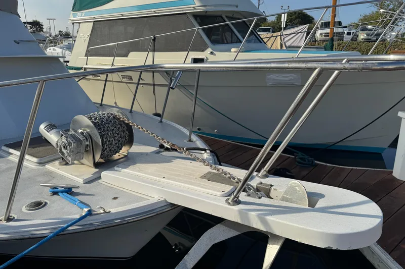 1984 Blackfin 32 Flybridge boat with anchor chain and winch on deck.