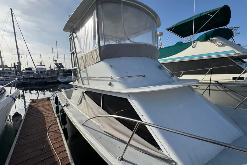 1984 Blackfin 32 Flybridge boat docked at marina, featuring classic design and flybridge.