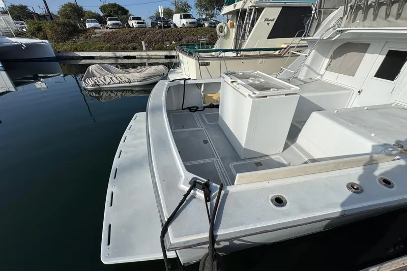 1984 Blackfin 32 Flybridge boat docked, featuring spacious deck and fishing setup.