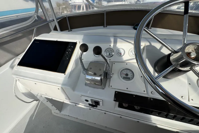 1984 Blackfin 32 Flybridge helm with steering wheel, gauges, and navigation equipment.