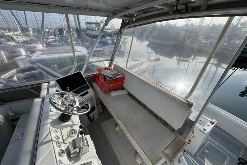 1984 Blackfin 32 Flybridge interior with helm, seating, and marina view.