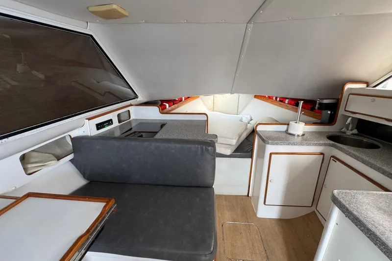 Interior of 1984 Blackfin 32 Flybridge boat with seating, kitchenette, and sleeping area.