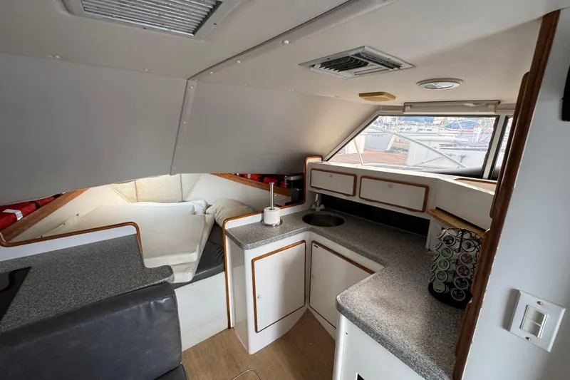 Interior of 1984 Blackfin 32 Flybridge boat with compact kitchen and sleeping area.