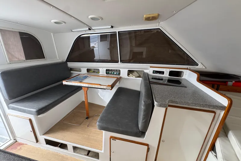 Interior of 1984 Blackfin 32 Flybridge with seating, table, and kitchenette.