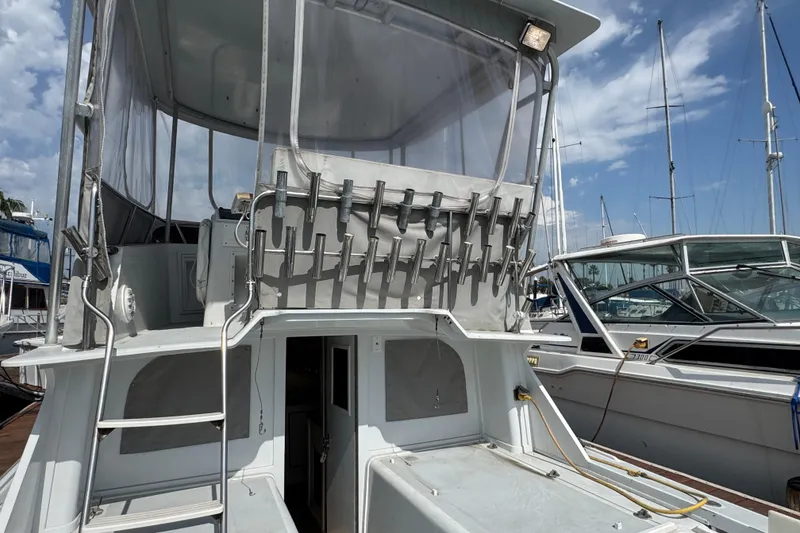 1984 Blackfin 32 Flybridge boat docked, featuring a spacious flybridge and rod holders.
