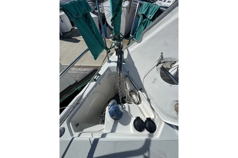 Bow of 1997 Catalina 36 MkII sailboat with anchor chain and green sail covers.