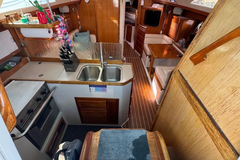 Interior of a 1997 Catalina 36 MkII sailboat, featuring a compact kitchen and cozy seating area.