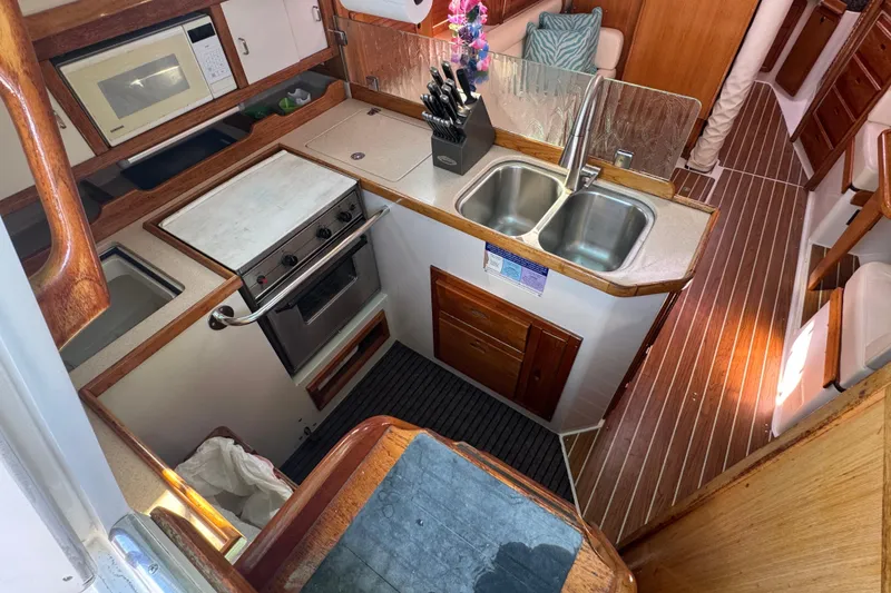 Interior of 1997 Catalina 36 MkII sailboat kitchen with stove, sink, and microwave.
