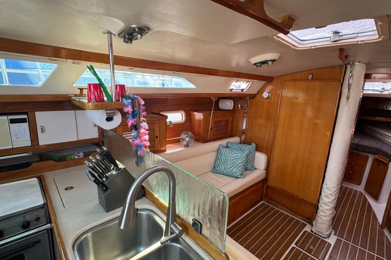 Interior of 1997 Catalina 36 MkII sailboat with cozy seating and modern kitchen amenities.