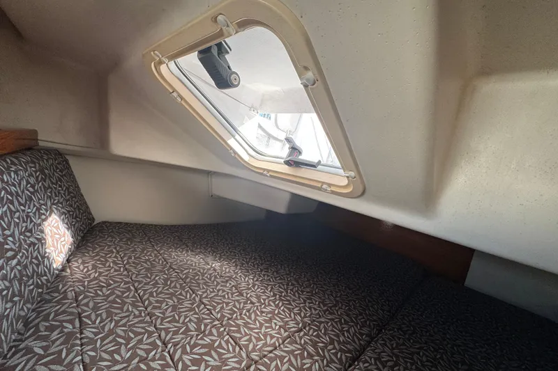 Interior cabin of 1997 Catalina 36 MkII sailboat with patterned cushions and window.