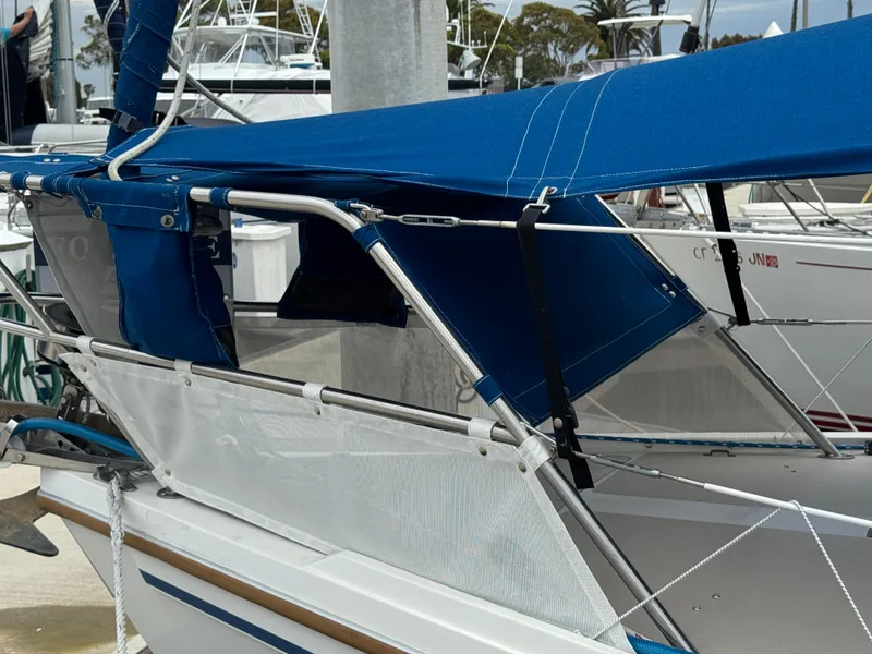 1985 Catalina 36 MK1 sailboat with blue canvas cover docked at marina.
