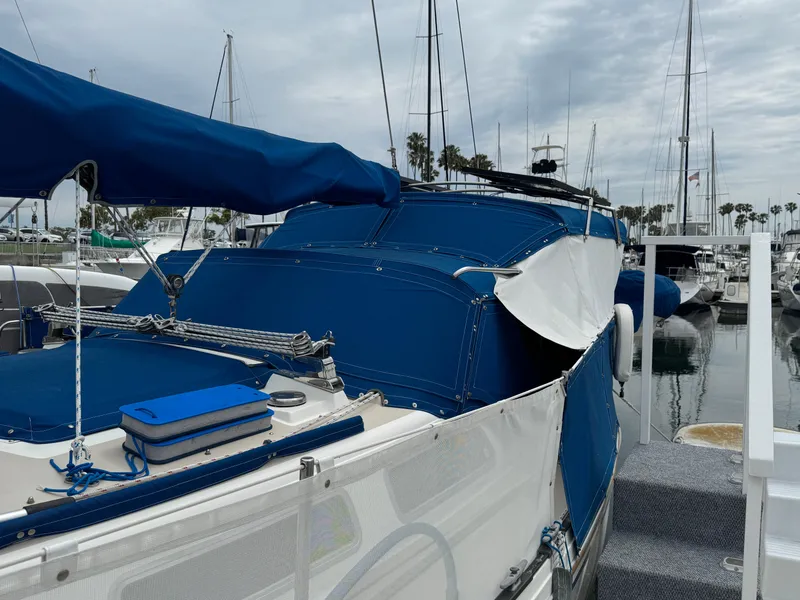 1985 Catalina 36 MK1 sailboat with blue covers docked in a marina.