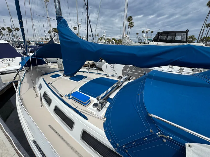 1985 Catalina 36 MK1 sailboat with blue covers docked at marina.