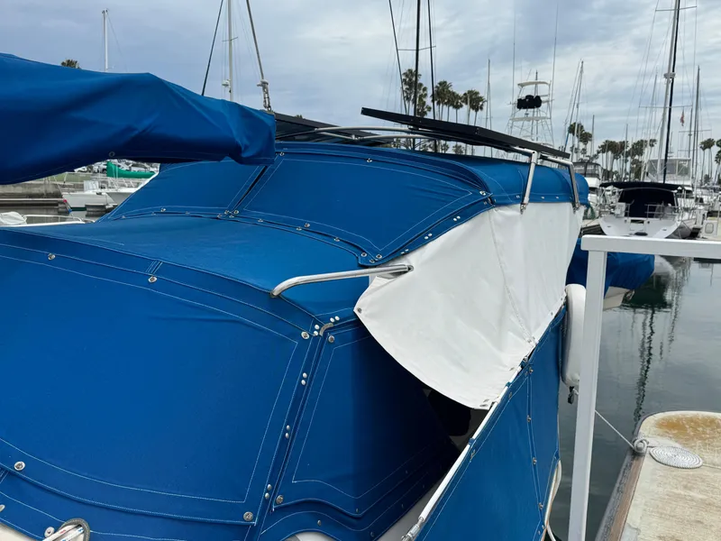 1985 Catalina 36 MK1 sailboat with blue canvas cover docked at marina.