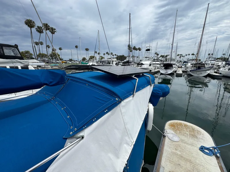 Catalina 36 MK1 sailboat docked in marina, featuring blue cover and solar panel.