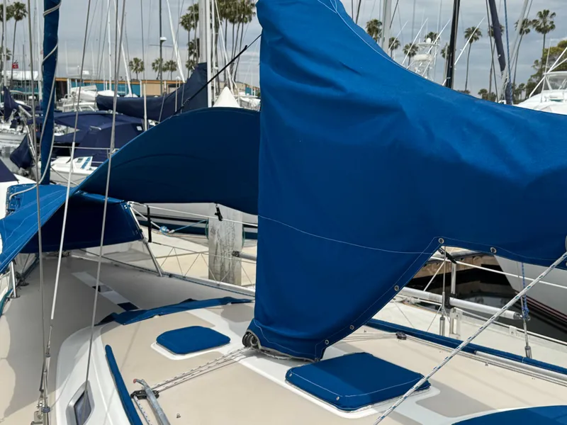 1985 Catalina 36 MK1 sailboat with blue sail covers docked at a marina.