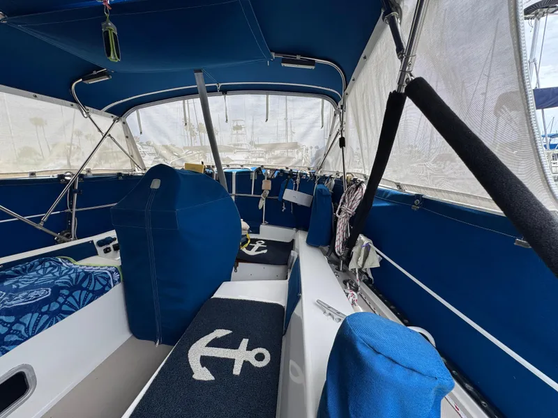 Interior of 1985 Catalina 36 MK1 sailboat with blue upholstery and anchor-themed decor.