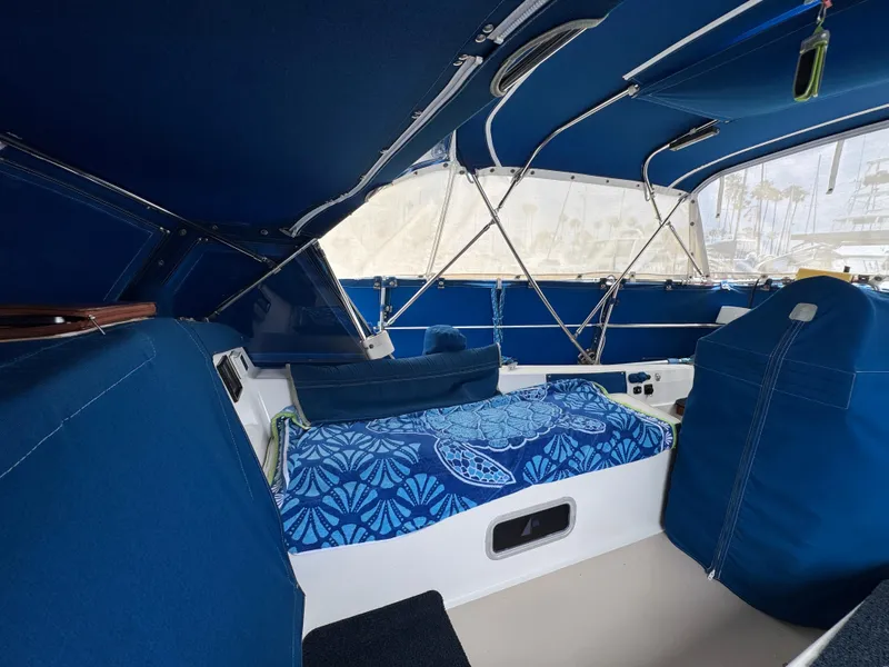 Interior of 1985 Catalina 36 MK1 sailboat with blue upholstery and patterned bedding.