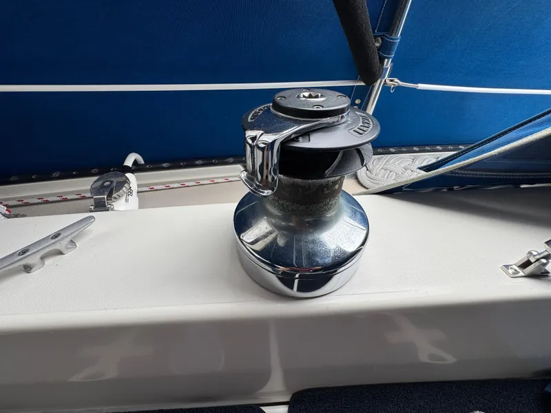 Winch on 1985 Catalina 36 MK1 sailboat deck with blue canvas background.