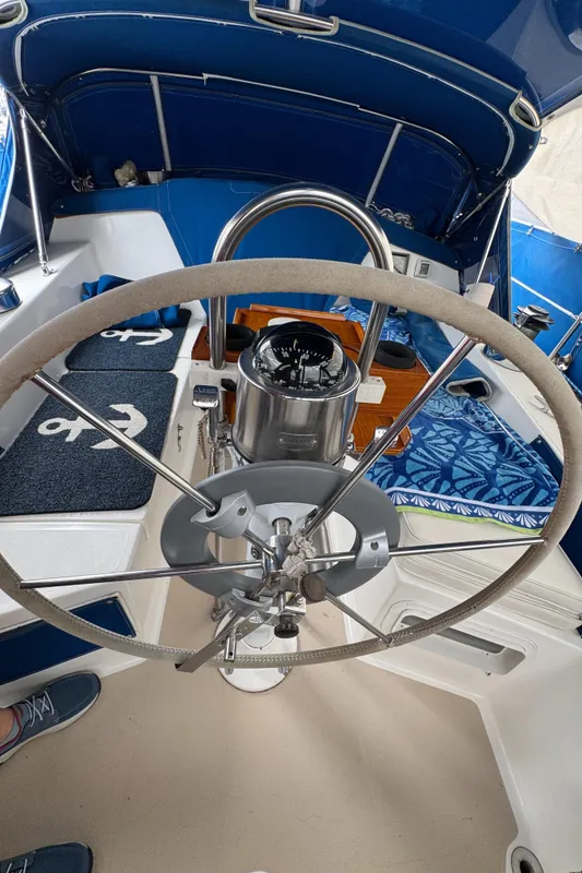 Cockpit of 1985 Catalina 36 MK1 sailboat with steering wheel and nautical decor.