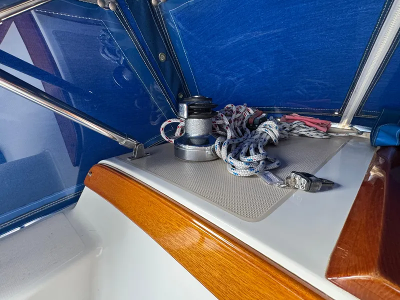 1985 Catalina 36 MK1 sailboat cockpit with winch, ropes, and blue canopy.