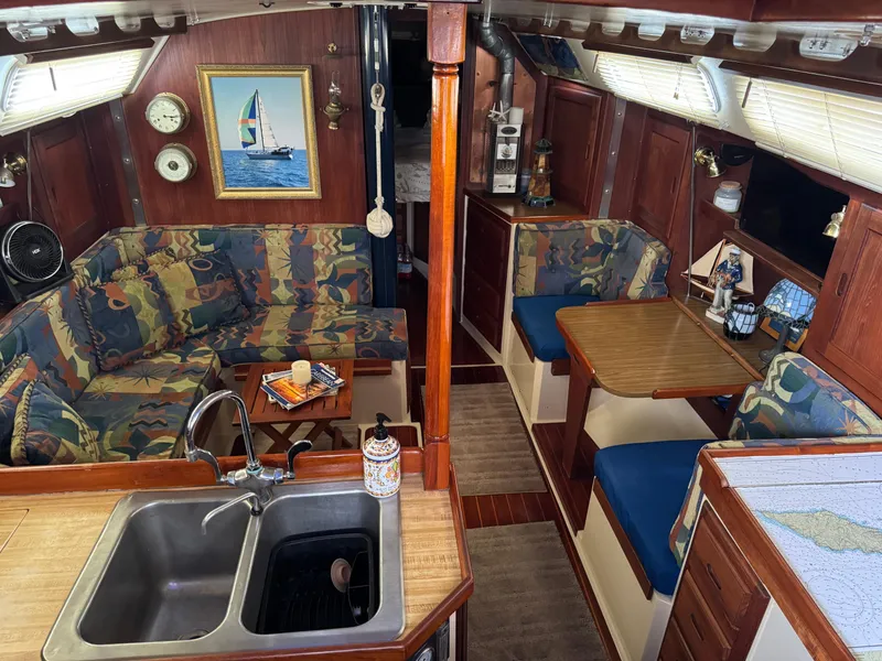 Interior of 1985 Catalina 36 MK1 sailboat with cozy seating and wooden finishes.