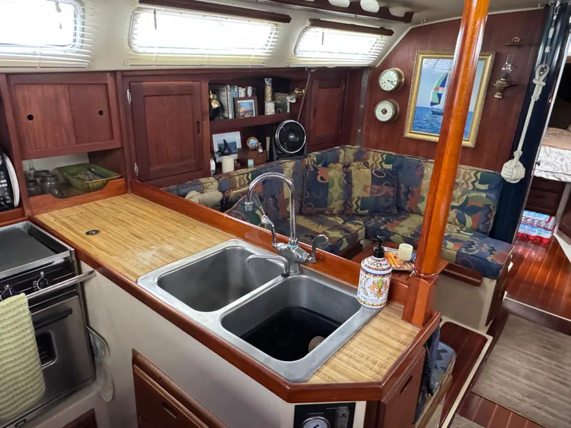 Interior of 1985 Catalina 36 MK1 sailboat with kitchen and cozy seating area.