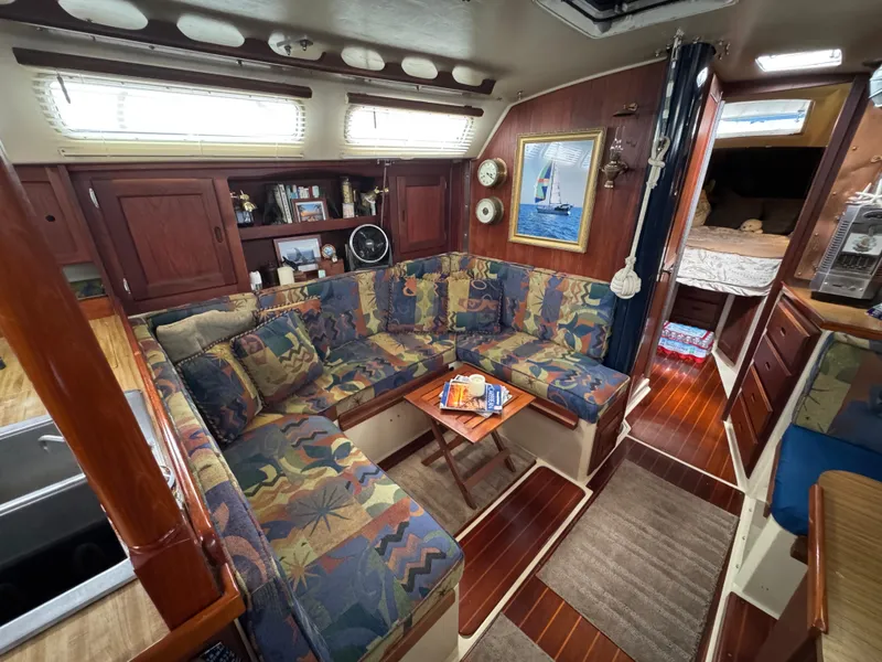 Interior of 1985 Catalina 36 MK1 sailboat with colorful seating and wooden accents.