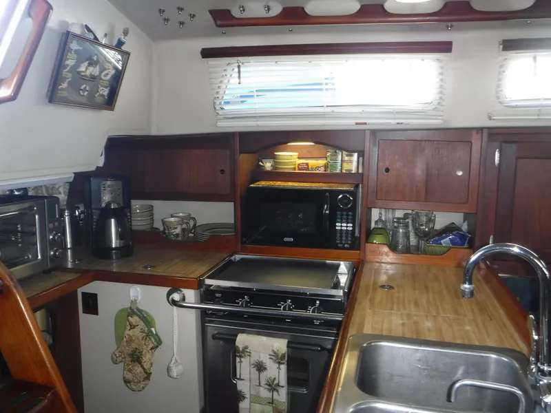 1985 Catalina 36 MK1 yacht kitchen with stove, microwave, and sink.