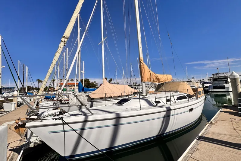 1995 Catalina 36 MkII sailboat docked at marina under clear blue sky.