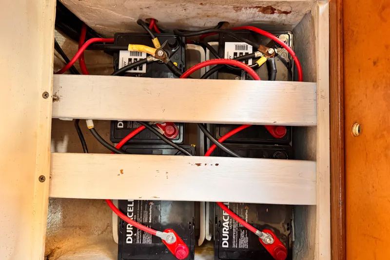 Battery compartment of a 1995 Catalina 36 MkII sailboat with connected cables.