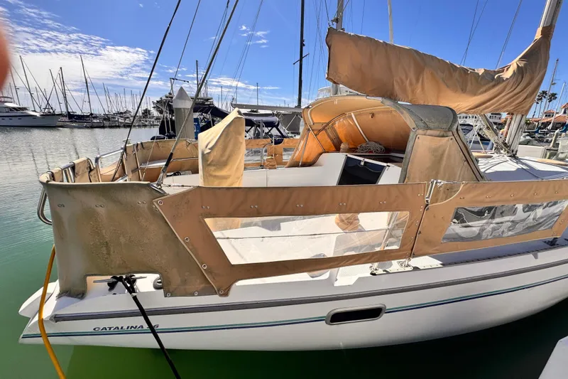 1995 Catalina 36 MkII sailboat docked in a marina, featuring tan canvas covers.