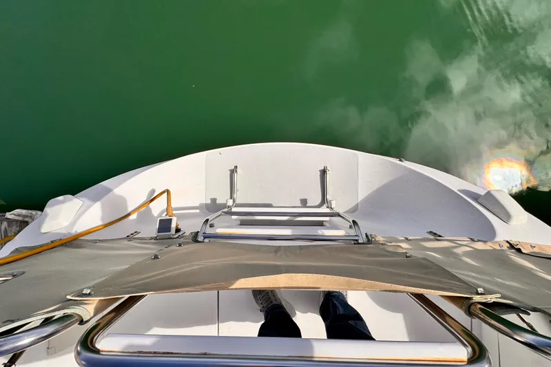 View from the stern of a 1995 Catalina 36 MkII sailboat, overlooking green water.