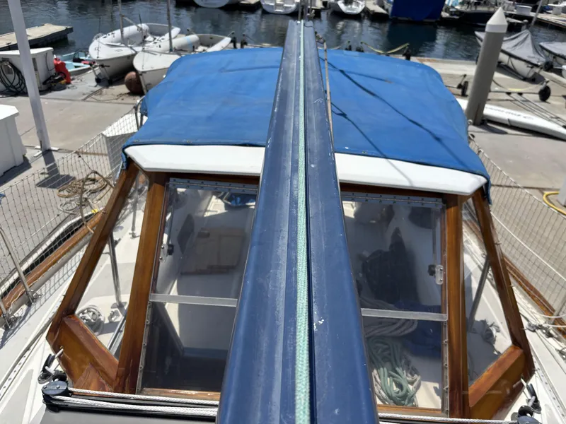 1982 Norseman 447 sailboat with blue cover docked at marina.