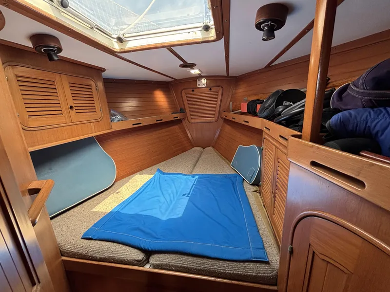 Cozy cabin interior of 1982 Norseman 447 sailboat with wooden finish and skylight.