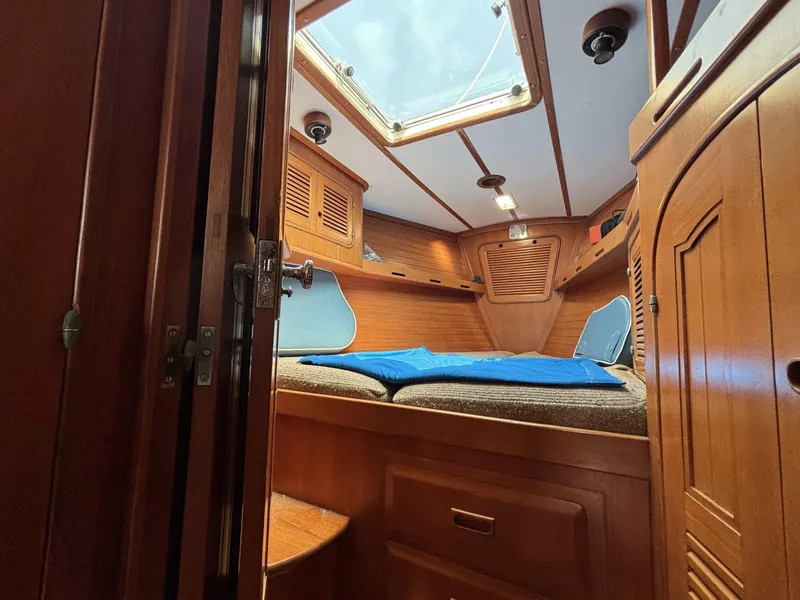 Cozy cabin interior of 1982 Norseman 447 sailboat with wooden finish and skylight.