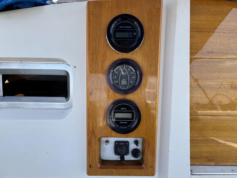 Wooden dashboard with speed, distance, and depth gauges on a 1982 Norseman 447 boat.