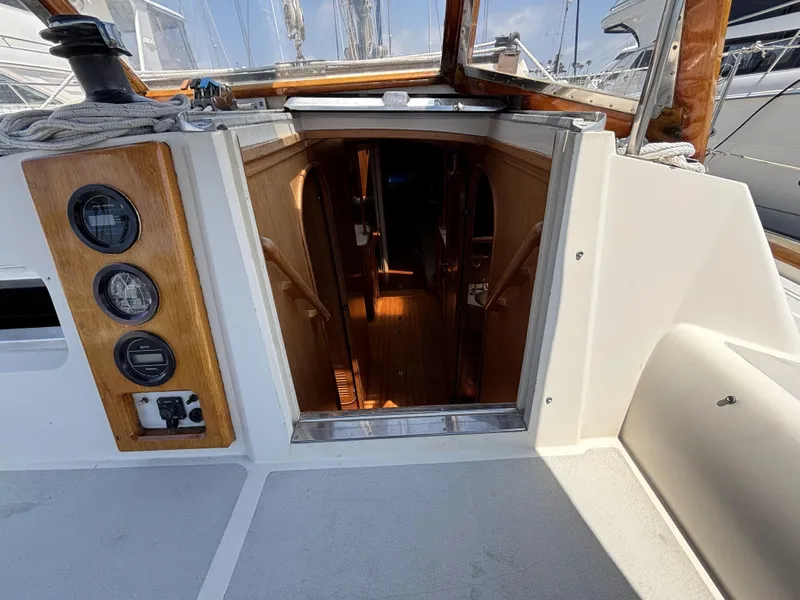 Cockpit view of 1982 Norseman 447 sailboat, showing cabin entrance and wooden interior.