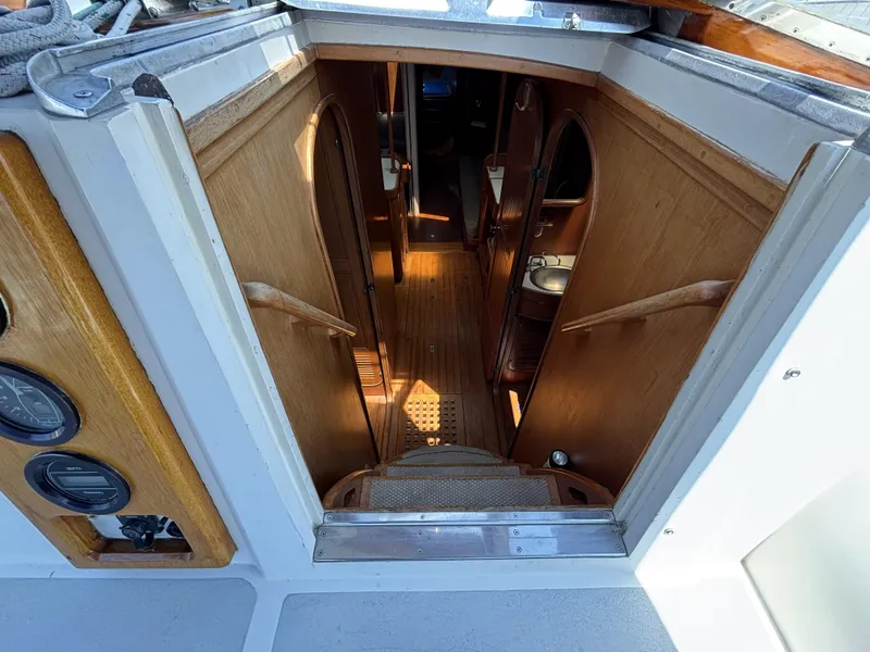 Interior view of 1982 Norseman 447 yacht, featuring wooden stairs and cabin entry.