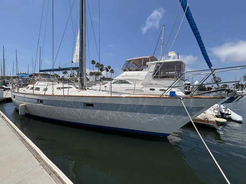 Sailboat docked at marina, Norseman 447, 1982 model, under clear blue sky.