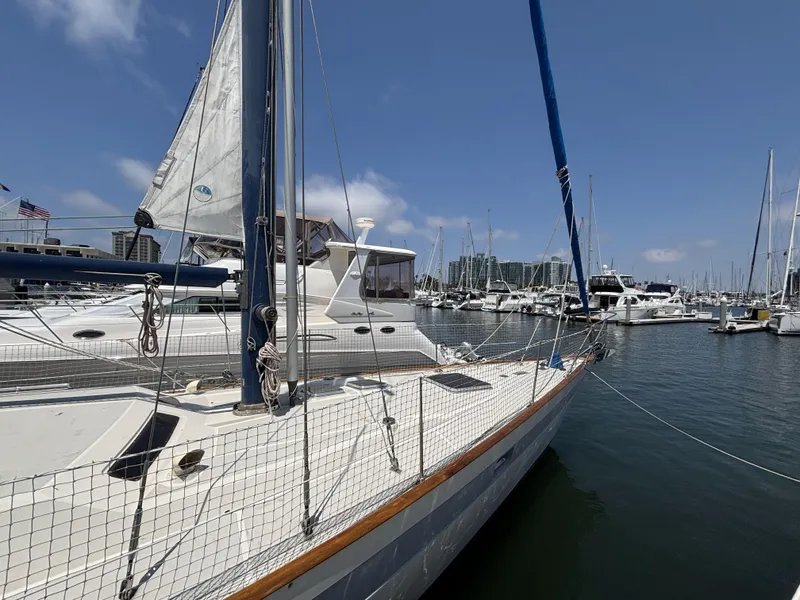 Sailboat Norseman 447, 1982 model, docked in a marina under clear blue skies.
