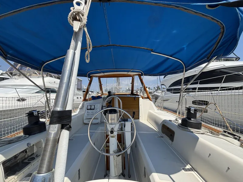 Cockpit of 1982 Norseman 447 sailboat with blue canopy and steering wheel.