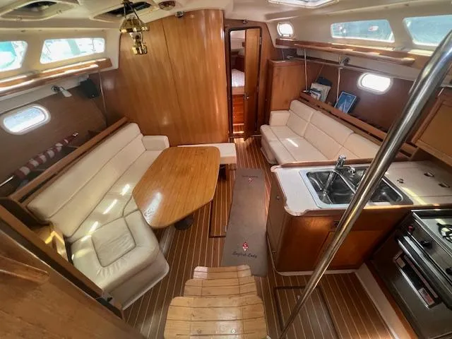 Interior of a 2002 Catalina 350 sailboat with wood finishes and cozy seating.
