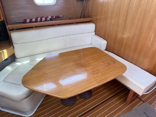 Cozy Catalina 350 sailboat interior with wooden table and cushioned seating, 2002 model.