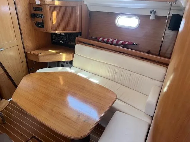 Interior of 2002 Catalina 350 sailboat with wooden table and white seating.