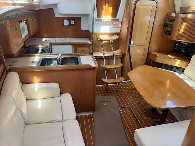 Interior of 2002 Catalina 350 sailboat with kitchen, seating, and wooden finishes.
