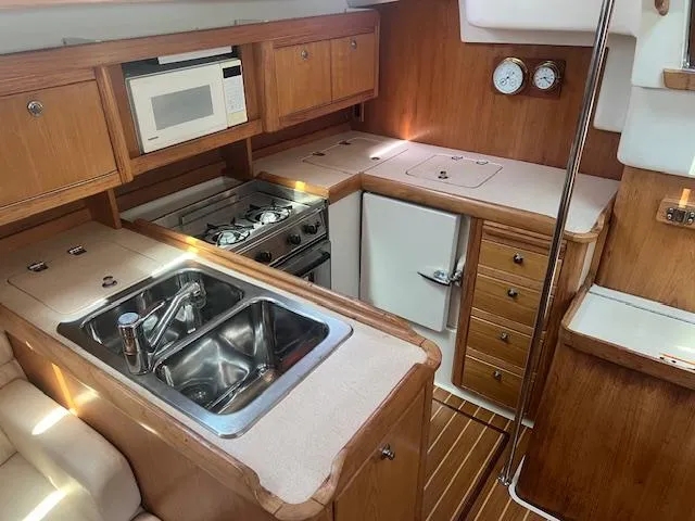 Interior of 2002 Catalina 350 yacht kitchen with stove, sink, and microwave.