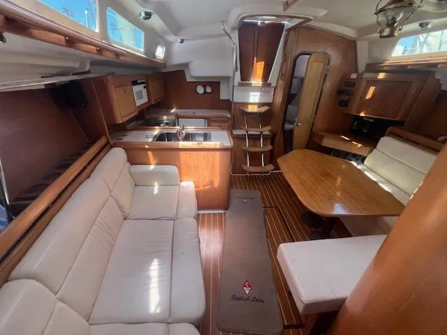 Interior of a 2002 Catalina 350 sailboat with cozy seating and wooden finishes.