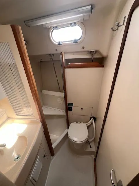 Compact bathroom in a 2002 Catalina 350 sailboat with sink, toilet, and shower.