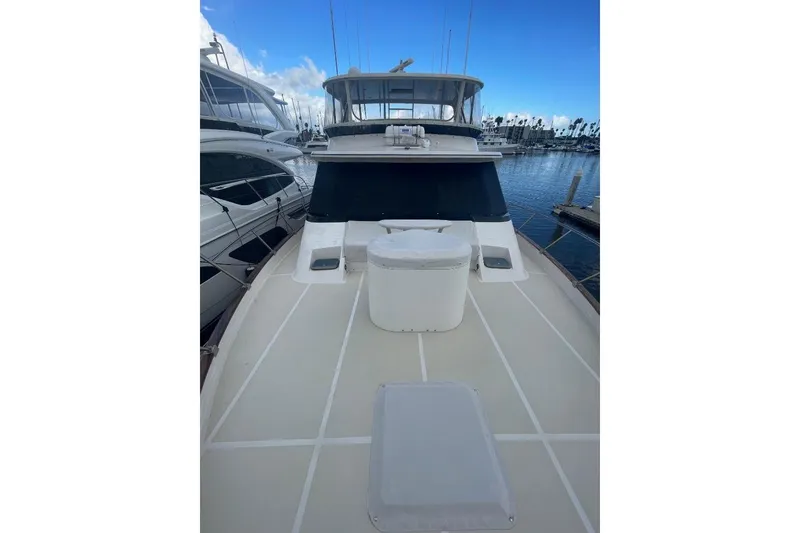 1990 Offshore Yachts 55 Pilothouse on calm marina waters, showcasing spacious deck.